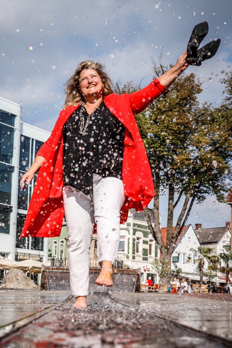 Birgit Gosejacob splashing barefeet waving pumps in the air