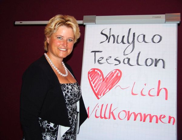 Birgit Gosejacob in front of a flipchart welcoming participants to a world cafe, in this case calles 